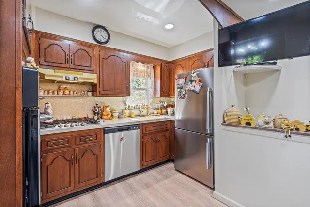 a kitchen with stainless steel appliances granite countertop a refrigerator and a stove top oven