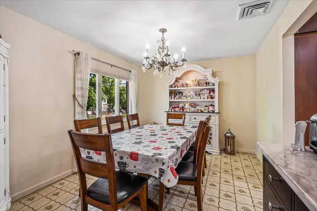 a view of a dining room with furniture and a chandelier