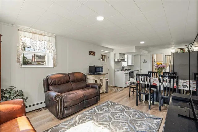 a living room with furniture a dining table and a window