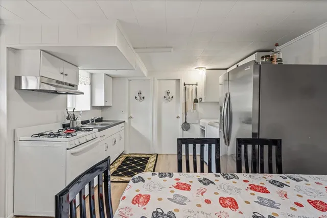 a kitchen with stainless steel appliances a sink a stove a refrigerator and cabinets