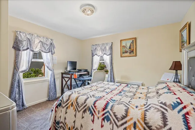 a bedroom with a bed and a table in it with window