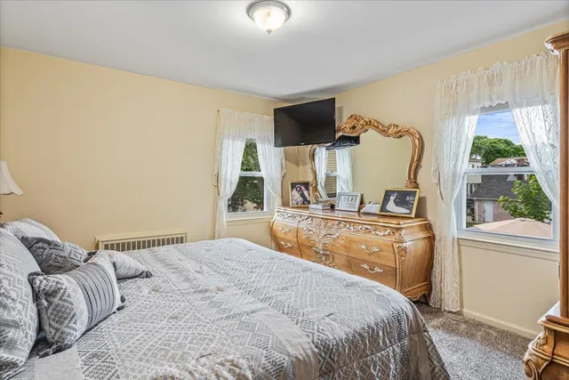 a bedroom with a bed flat screen tv and window