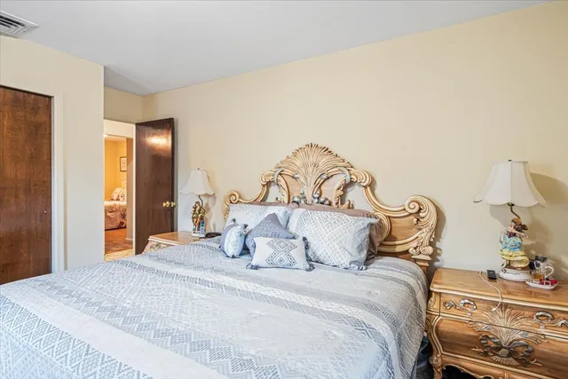 a bedroom with a bed and a lamp with the dresser