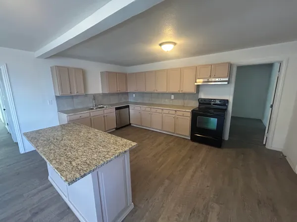a kitchen with a stove a refrigerator and a sink