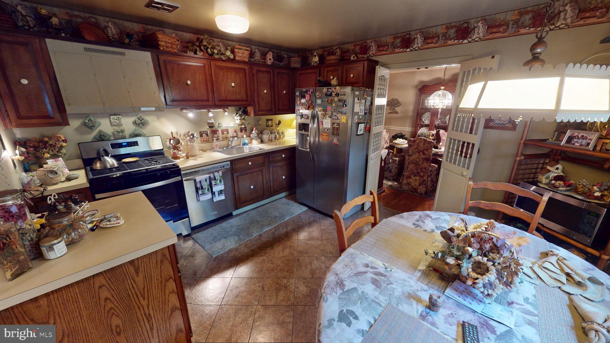 6911 Good Luck Road Hyattsville, MD 20784 - Photo 25 of 94 a kitchen with lots of wooden furniture and refrigerator