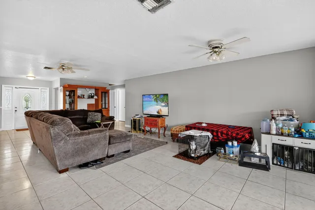 a living room with furniture and a ceiling fan