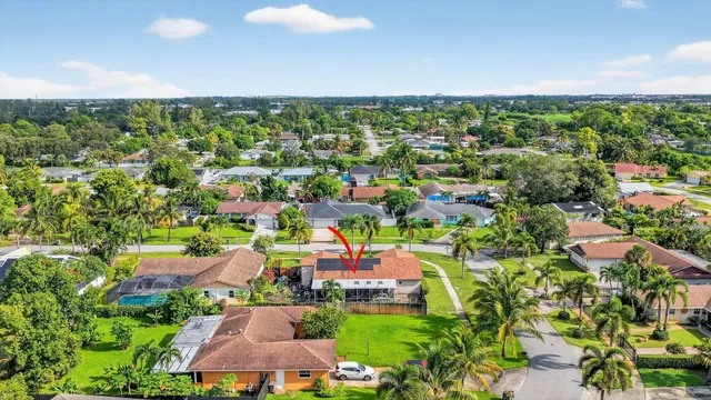 an aerial view of residential houses with outdoor space and trees