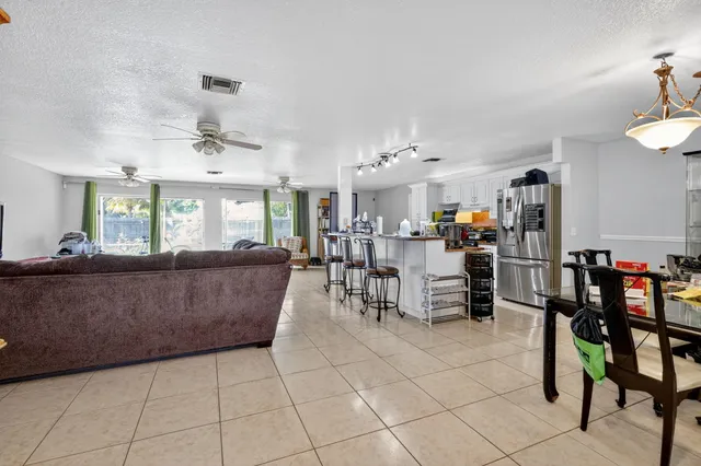 a living room with furniture and a dining table with kitchen view