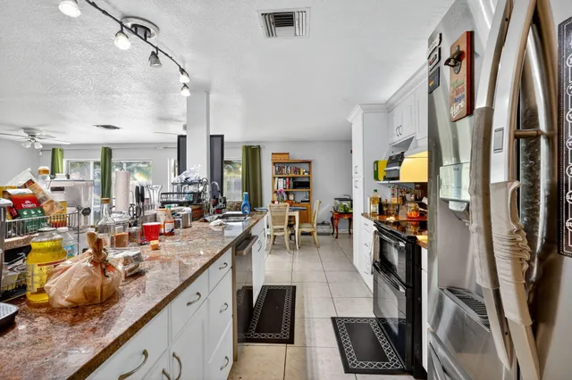 a kitchen with stainless steel appliances lots of counter top space and furniture