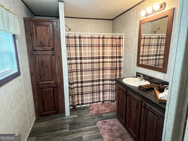 a bathroom with a sink a toilet a mirror and shower