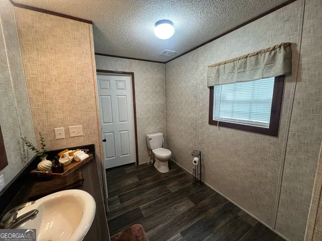 a bathroom with a toilet sink and mirror