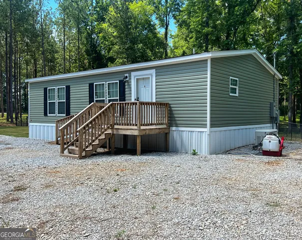 a view of a house with two chairs and a yard