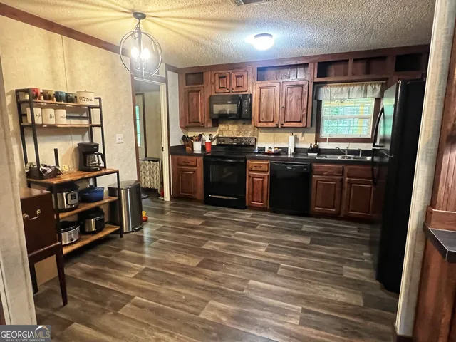 a kitchen with stainless steel appliances granite countertop a stove refrigerator and cabinets