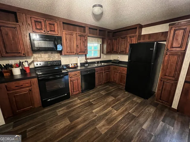 a kitchen with stainless steel appliances granite countertop a refrigerator stove and sink