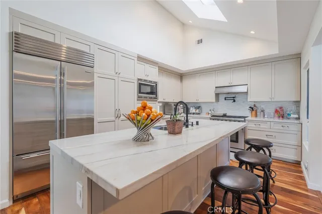 a kitchen with granite countertop a sink cabinets and appliances
