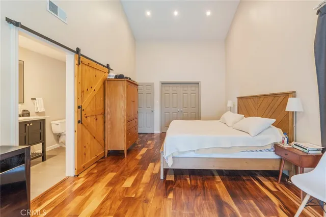 a bedroom with a bed and a wooden floor
