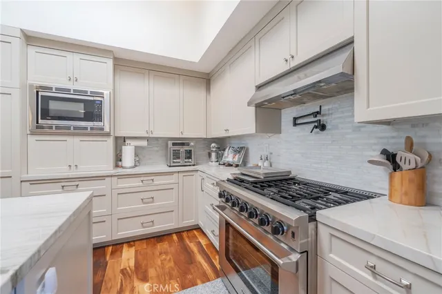 a kitchen with stainless steel appliances granite countertop a stove and a microwave