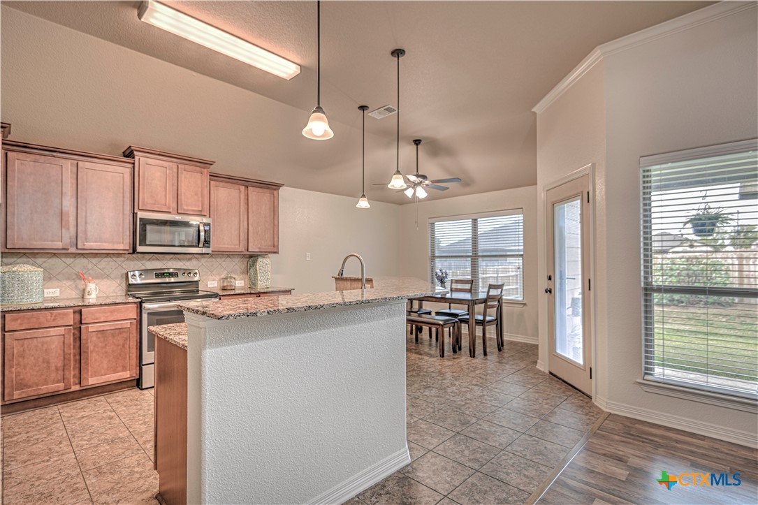 8405 Split Trl Cove Temple, TX 76502 - Photo 11 of 37 a kitchen with kitchen island a dining table chairs and white cabinets