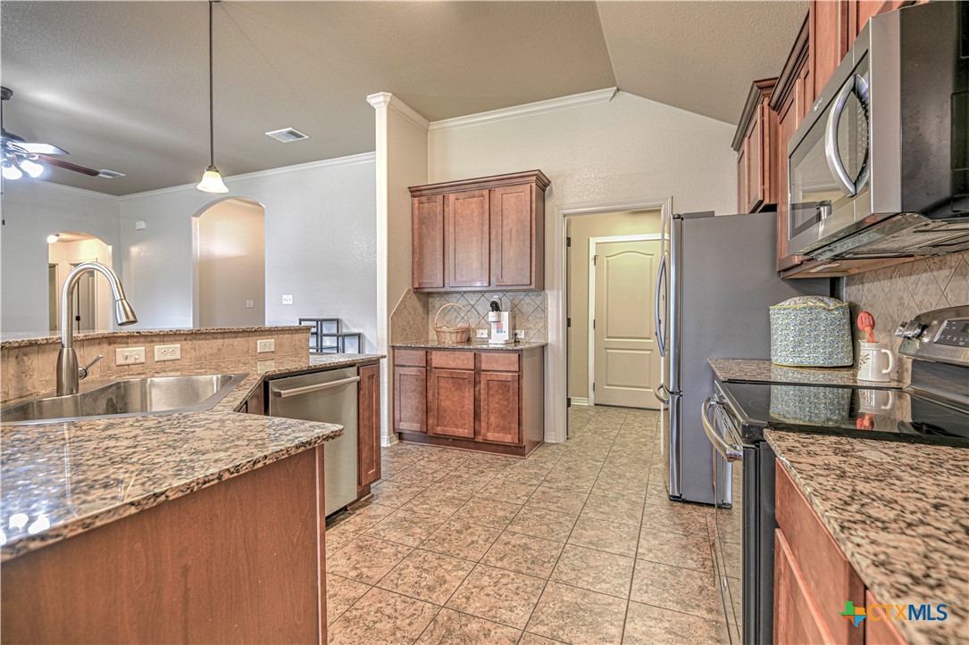 8405 Split Trl Cove Temple, TX 76502 - Photo 14 of 37 a kitchen with stainless steel appliances granite countertop a sink a stove and a refrigerator