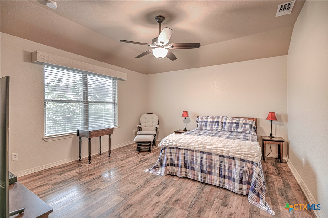 8405 Split Trl Cove Temple, TX 76502 - Photo 18 of 37 a bedroom with a bed and a chandelier