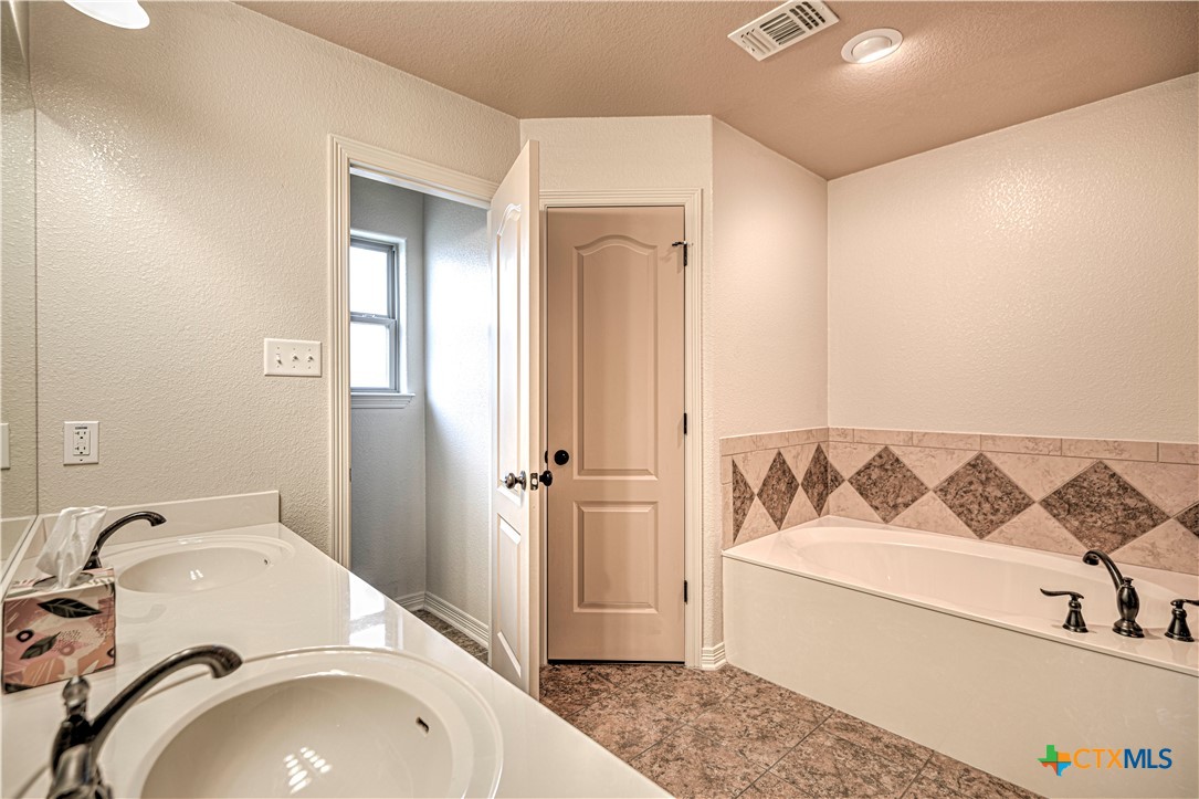 8405 Split Trl Cove Temple, TX 76502 - Photo 21 of 37 a bathroom with a sink and mirror with bathtub