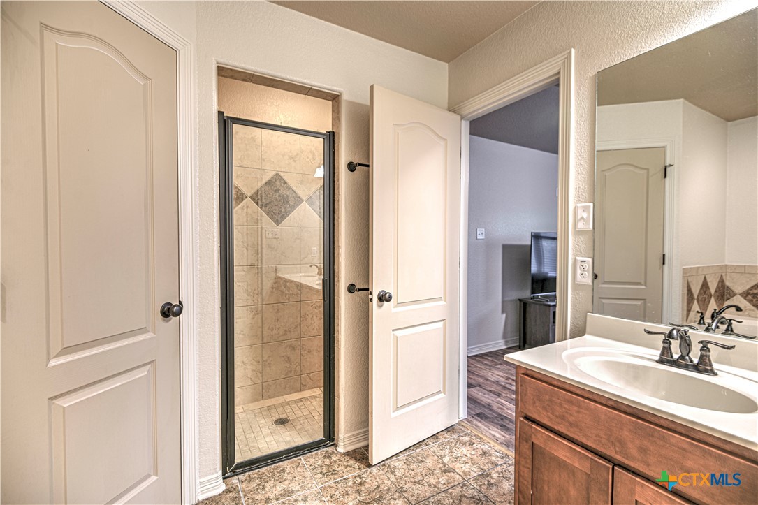 8405 Split Trl Cove Temple, TX 76502 - Photo 22 of 37 a bathroom with a sink a mirror and a shower