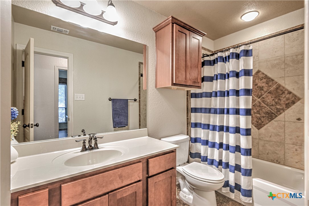 8405 Split Trl Cove Temple, TX 76502 - Photo 25 of 37 a bathroom with a sink a toilet and shower curtain