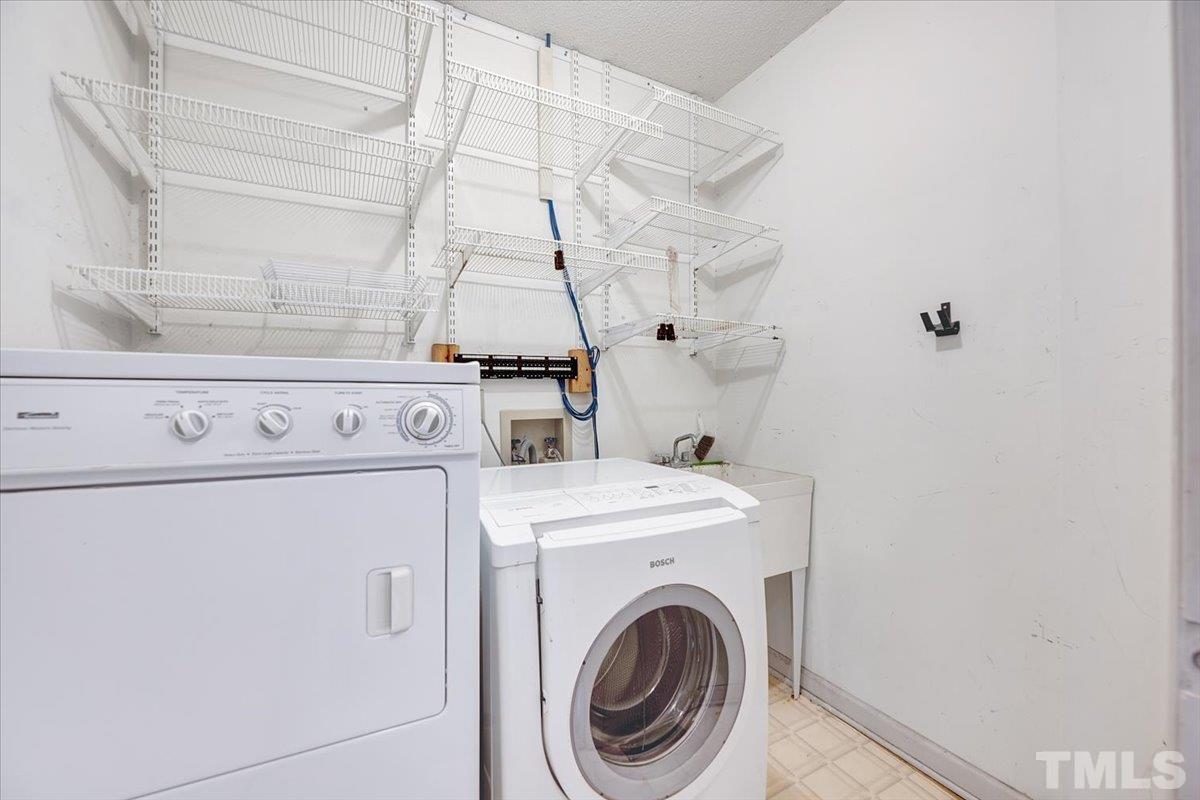 4003 Kettering Drive Durham, NC 27713 - Photo 16 of 28 a view of washer and dryer with bathroom in the background