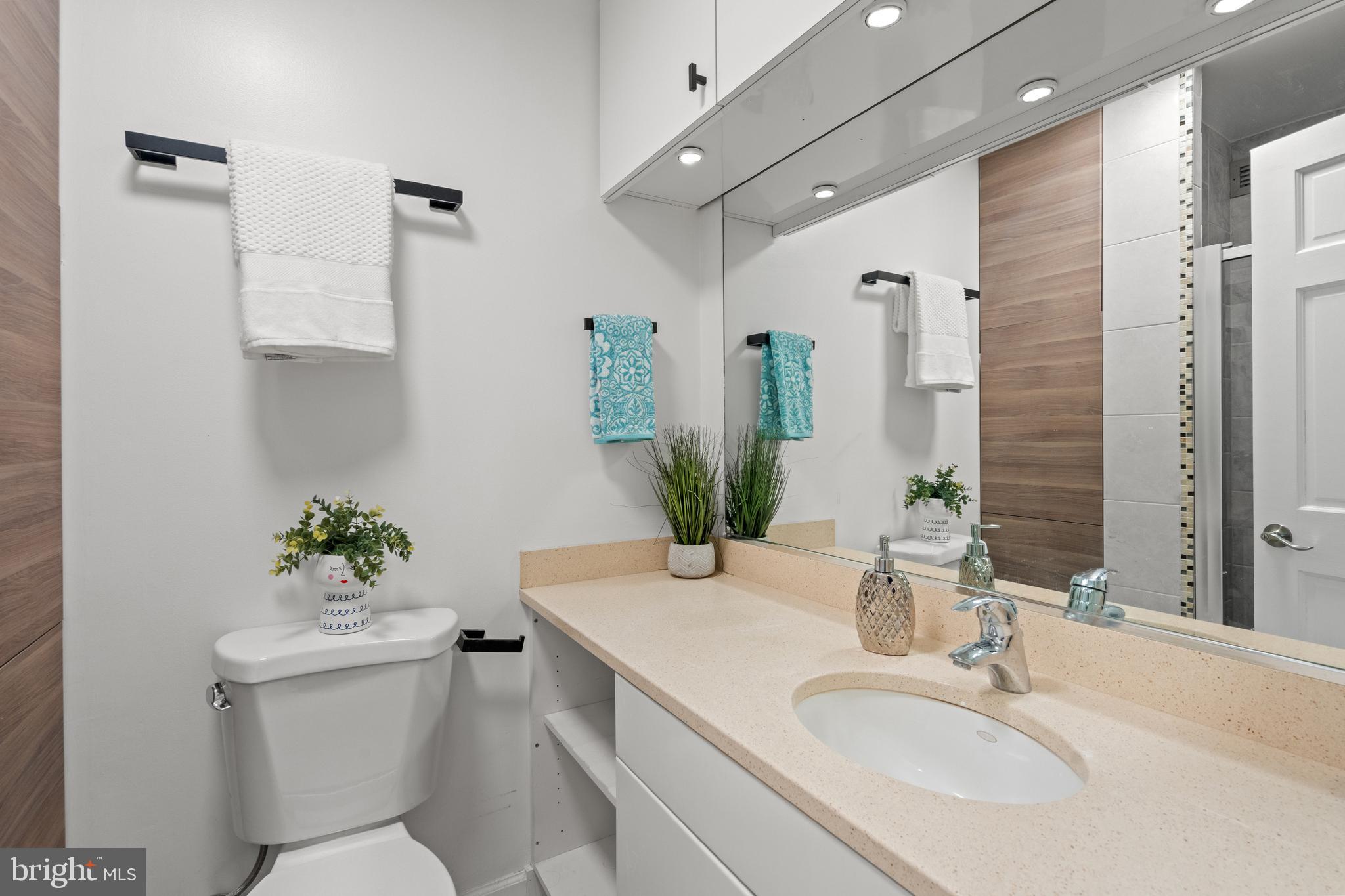 955 26th Street Northwest, Unit 707 Washington, DC 20037 - Photo 11 of 26 a bathroom with a granite countertop sink a toilet and a mirror