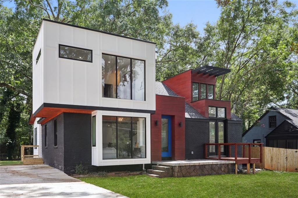 a view of a house with a yard and large tree