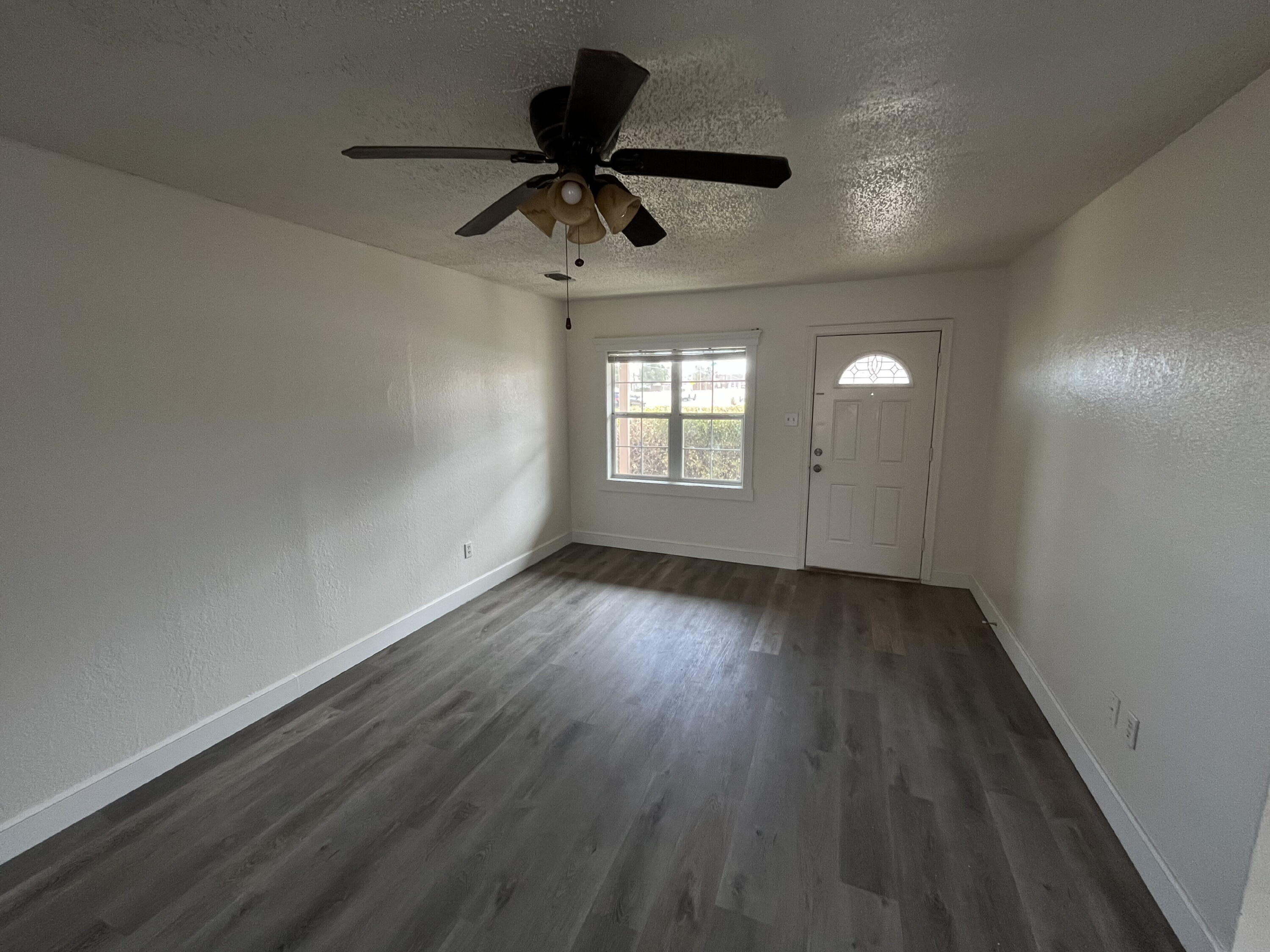 3404 30th Street Lubbock, TX 79410 - Photo 2 of 13 wooden floor in an empty room with a window