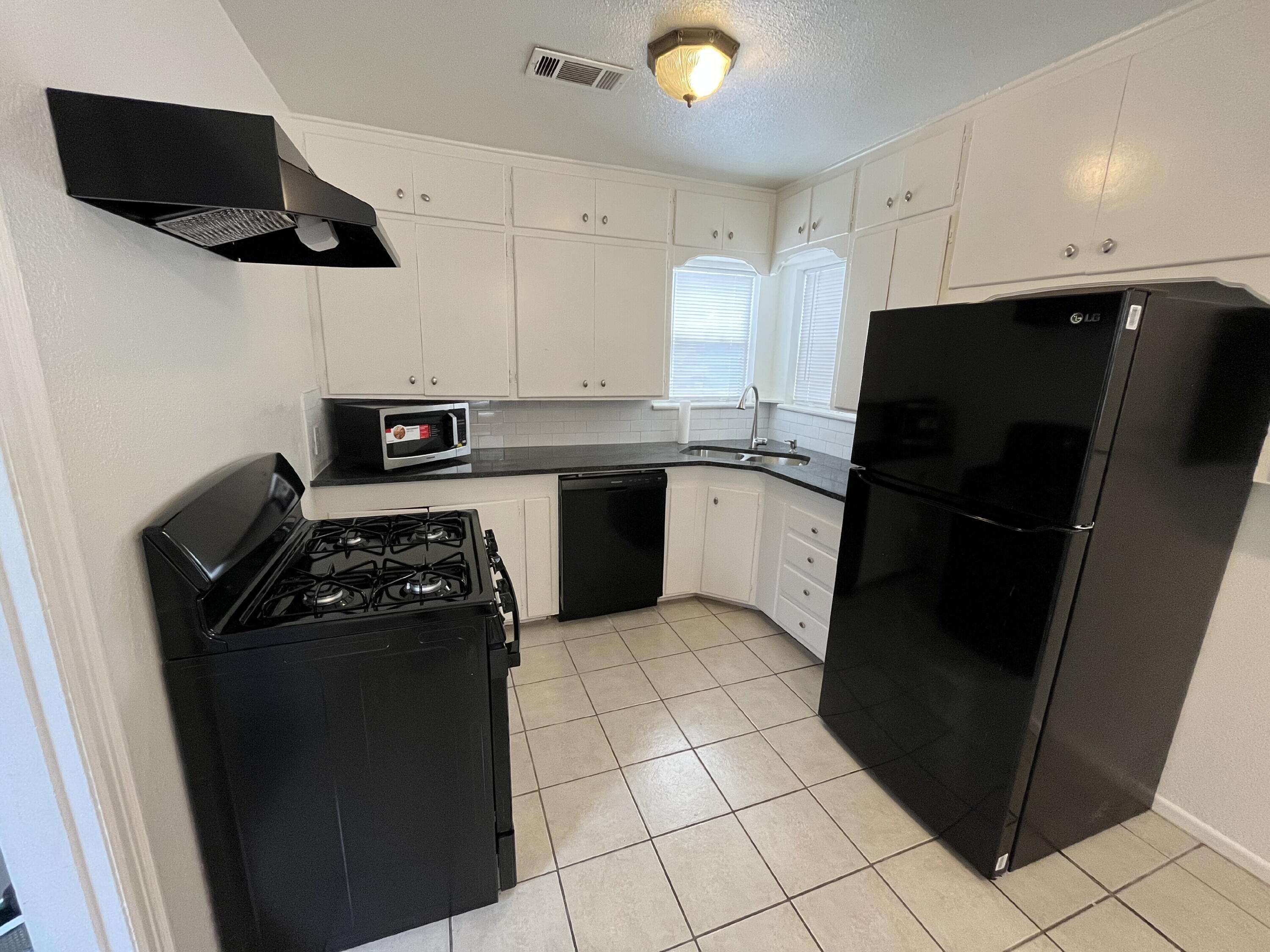 3404 30th Street Lubbock, TX 79410 - Photo 3 of 13 a kitchen with stainless steel appliances granite countertop a refrigerator a stove a microwave and a sink