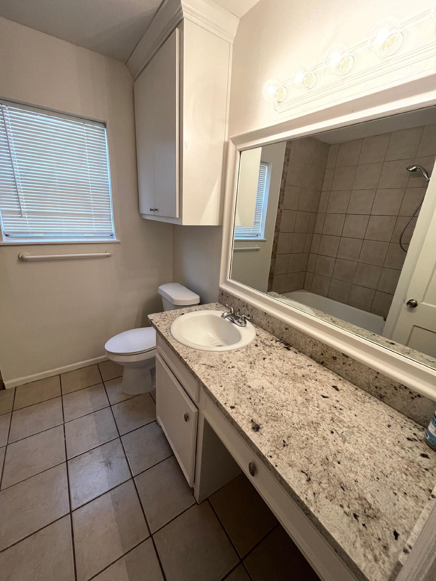 3404 30th Street Lubbock, TX 79410 - Photo 8 of 13 a bathroom with a granite countertop sink and a mirror