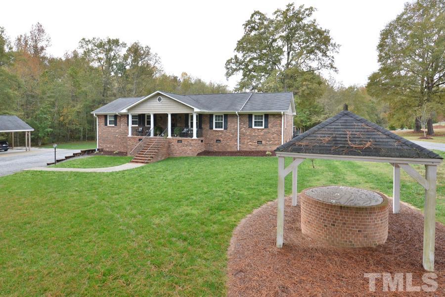 2260 Sanders Road Stem, NC 27581 - Photo 2 of 30 a view of a house with a yard potted plants and a fountain
