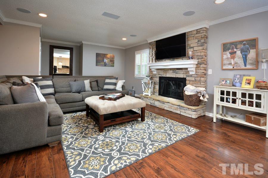 2260 Sanders Road Stem, NC 27581 - Photo 11 of 30 a living room with furniture a flat screen tv and a fireplace