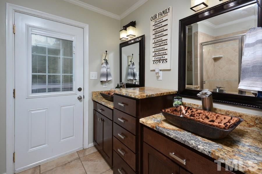 2260 Sanders Road Stem, NC 27581 - Photo 15 of 30 a bathroom with a granite countertop sink and a mirror