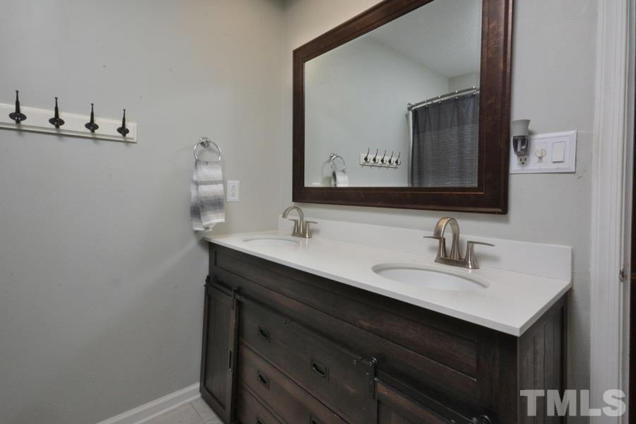 2260 Sanders Road Stem, NC 27581 - Photo 18 of 30 a bathroom with a sink vanity and a mirror