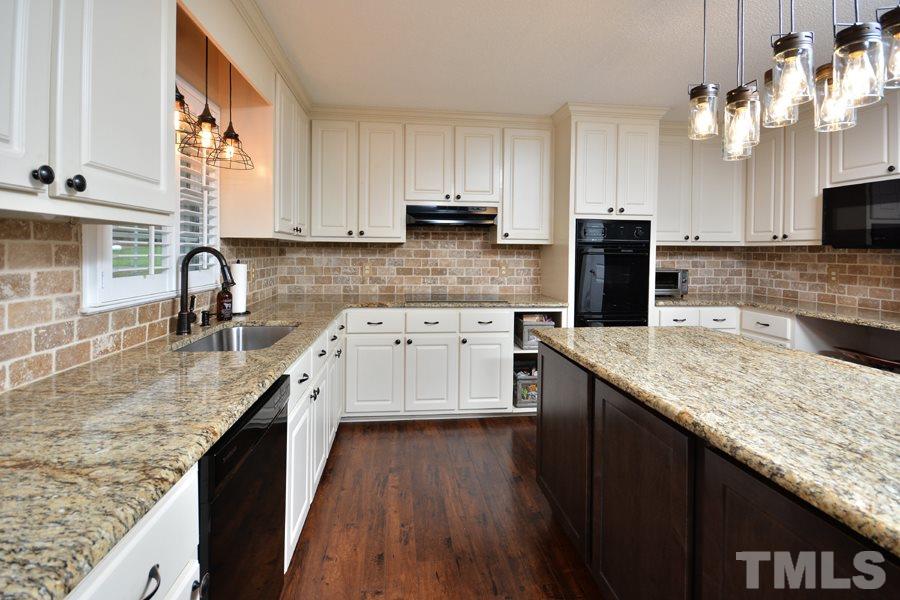 2260 Sanders Road Stem, NC 27581 - Photo 8 of 30 a kitchen with stainless steel appliances granite countertop a sink dishwasher a stove top oven a refrigerator with island and chairs