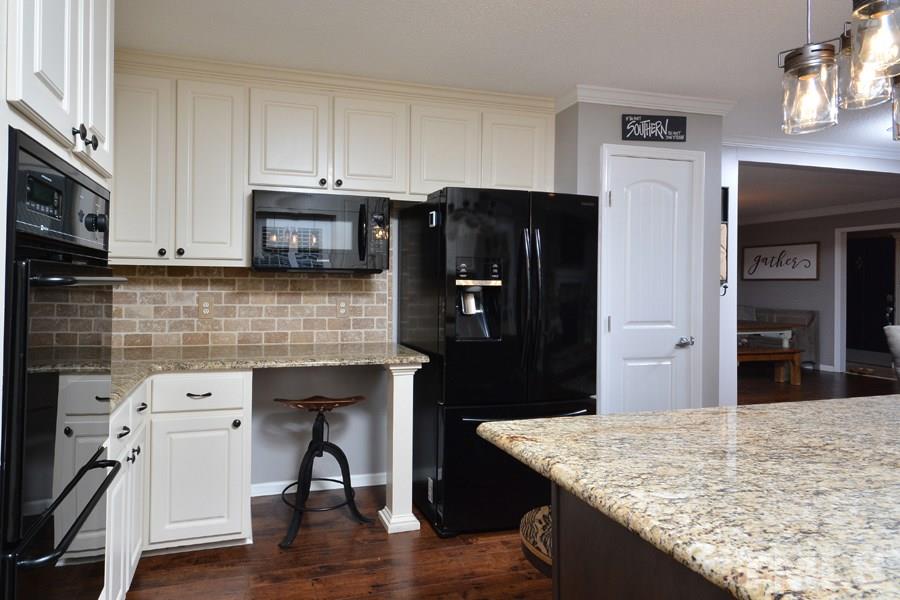 2260 Sanders Road Stem, NC 27581 - Photo 10 of 30 a kitchen with stainless steel appliances granite countertop a refrigerator and a stove top oven