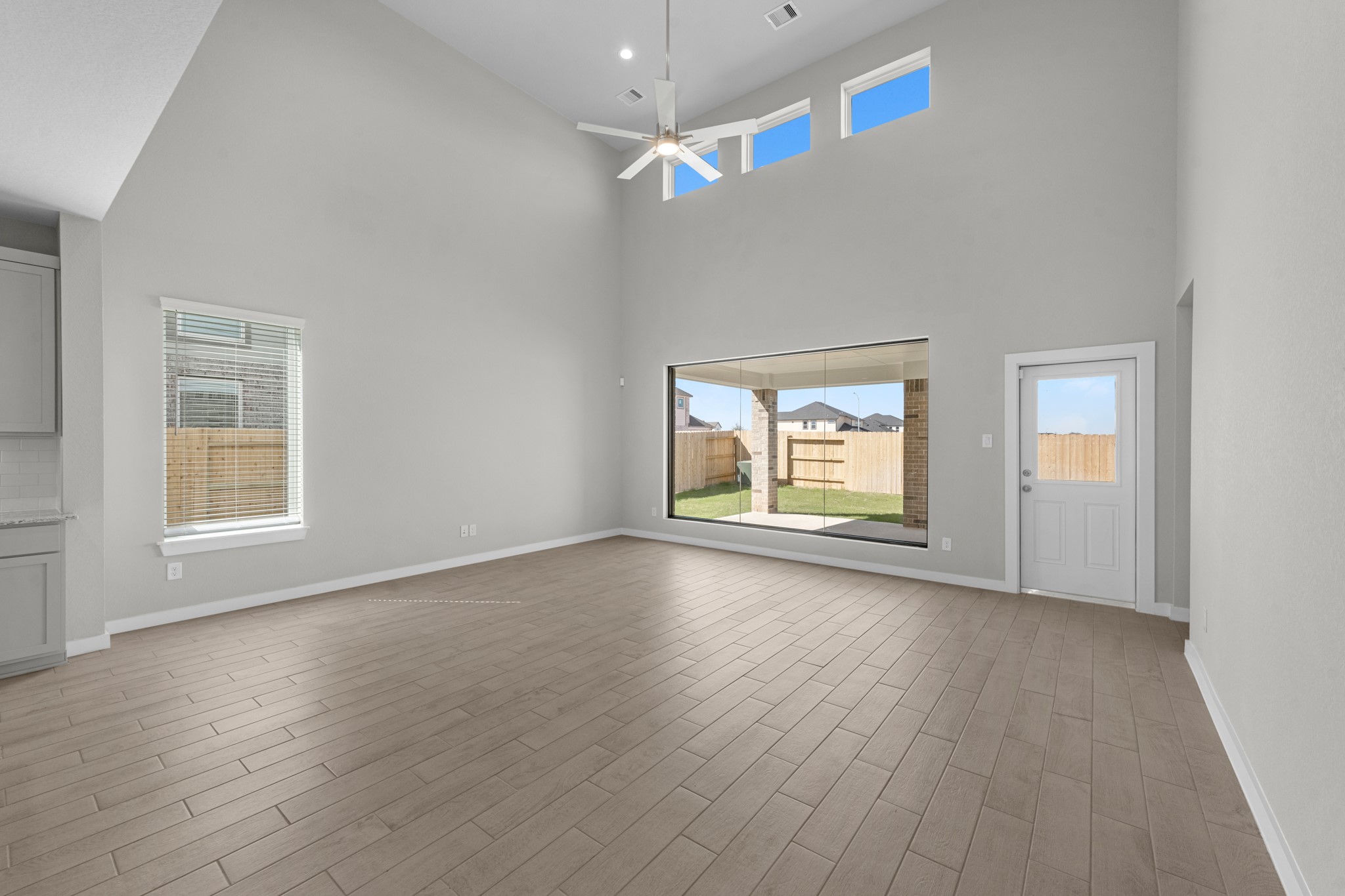 2129 Sunflower View Street Brookshire, TX 77423 - Photo 8 of 29 an empty room with wooden floor chandelier fan and windows