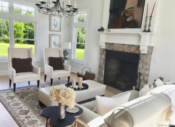 a living room with furniture a chandelier and a fireplace