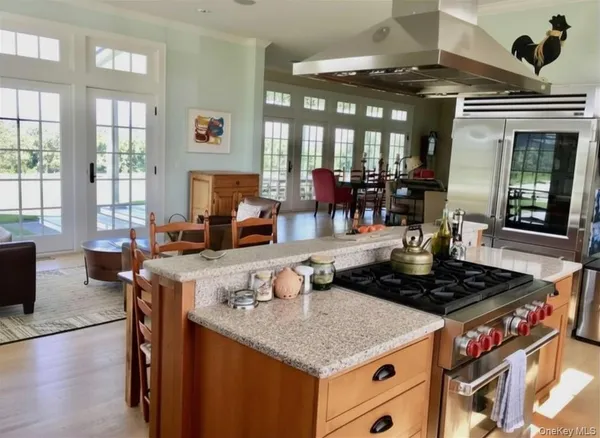 a living room with furniture a fireplace and large windows