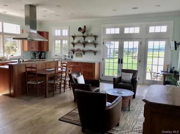 a living room with furniture a large window and wooden floor