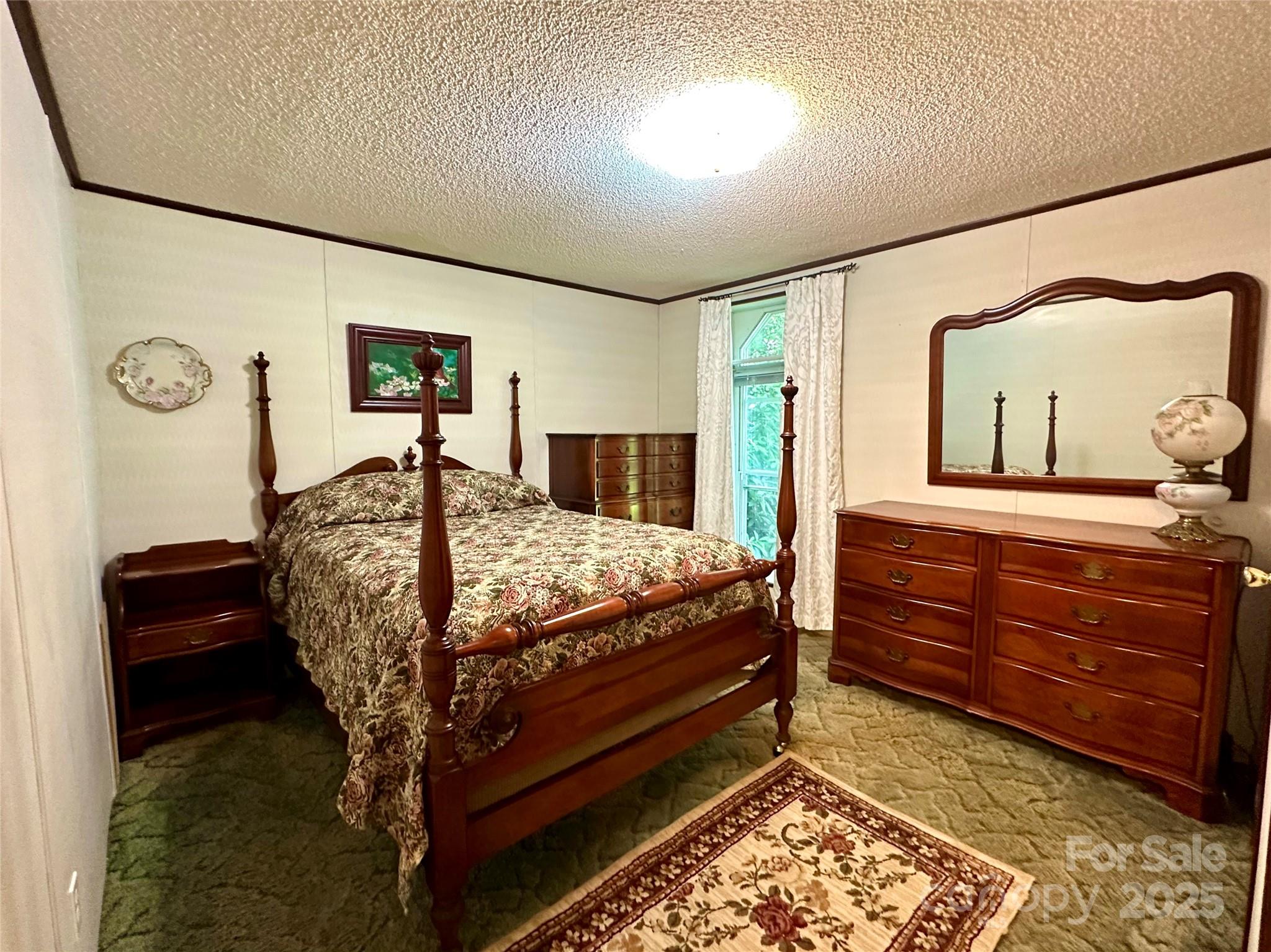 572 Blue Rdg Parkway Spruce Pine, NC 28777 - Photo 15 of 38 a bed sitting in a bedroom next to a window and dresser