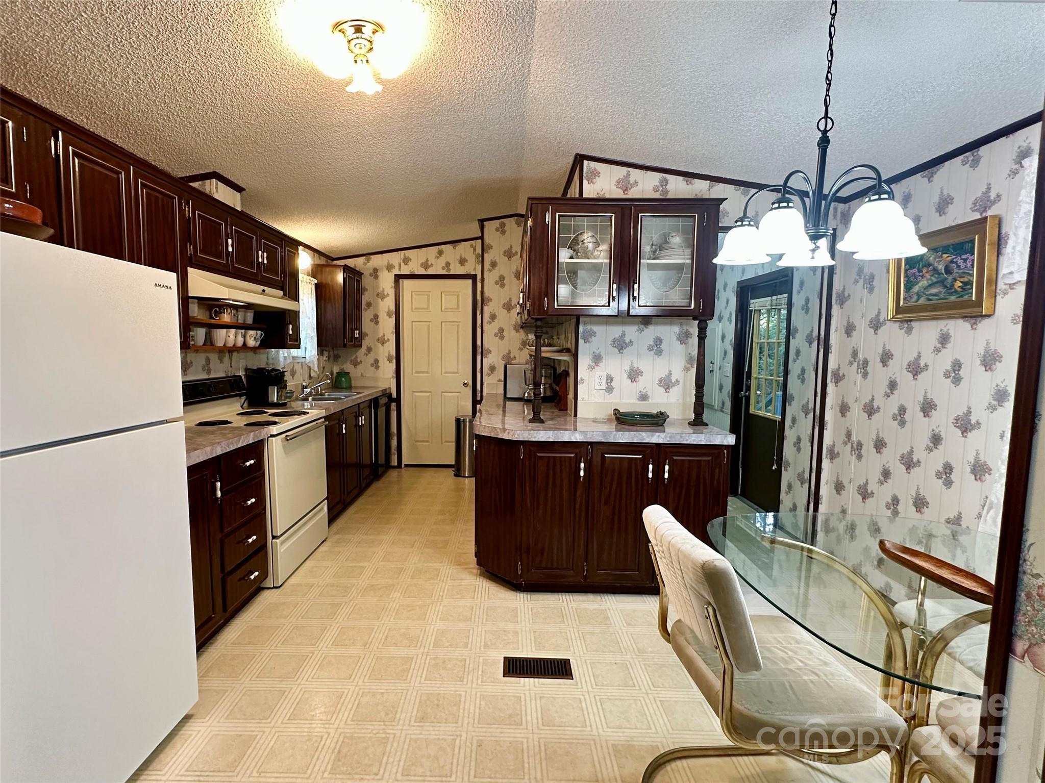 572 Blue Rdg Parkway Spruce Pine, NC 28777 - Photo 7 of 38 a kitchen with stainless steel appliances kitchen island granite countertop a refrigerator a oven a sink with island and chairs