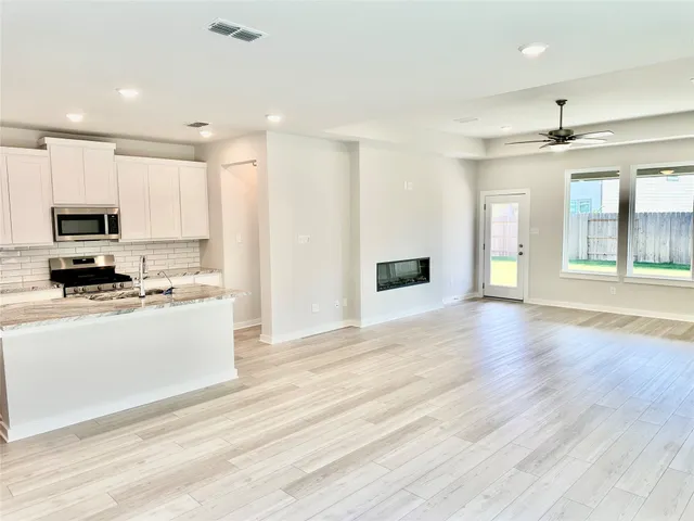 a view of kitchen with granite countertop stove top oven and sink