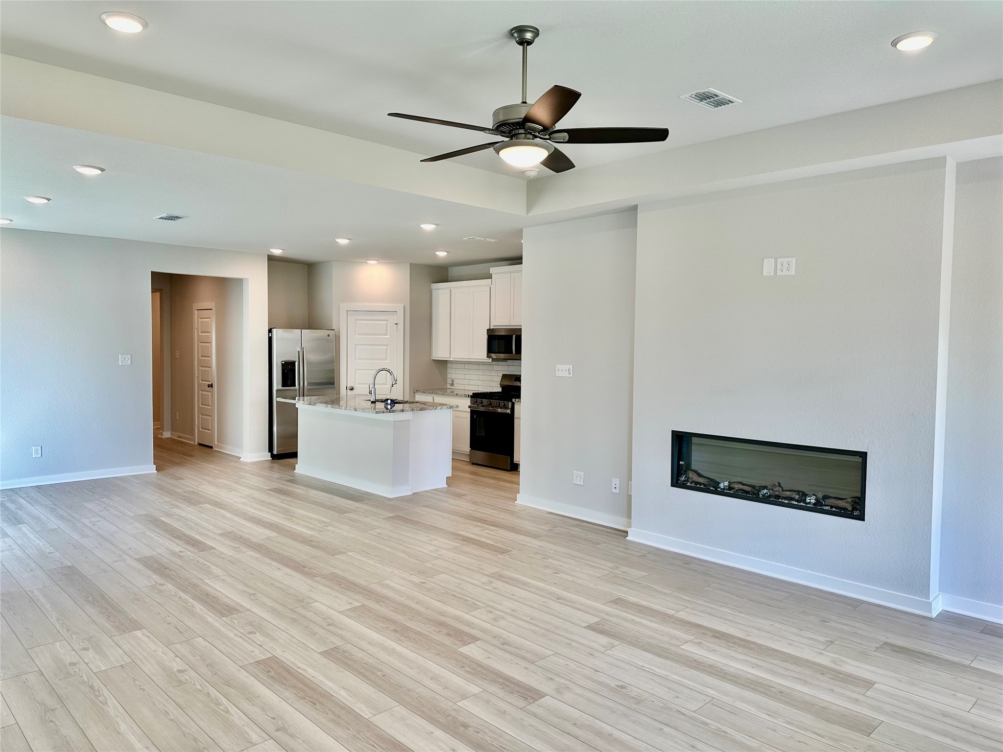21619 Flannel Bush Lane Cypress, TX 77433 - Photo 16 of 34 a view of a kitchen with a microwave and a ceiling fan