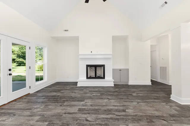 a view of an empty room with a window and fireplace