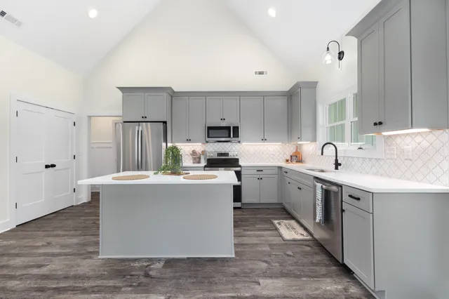 a kitchen with kitchen island a sink stove and refrigerator