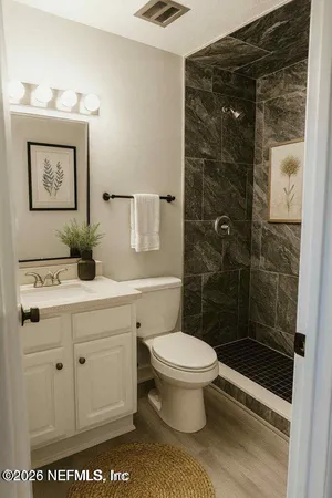 a bathroom with a sink a toilet and shower